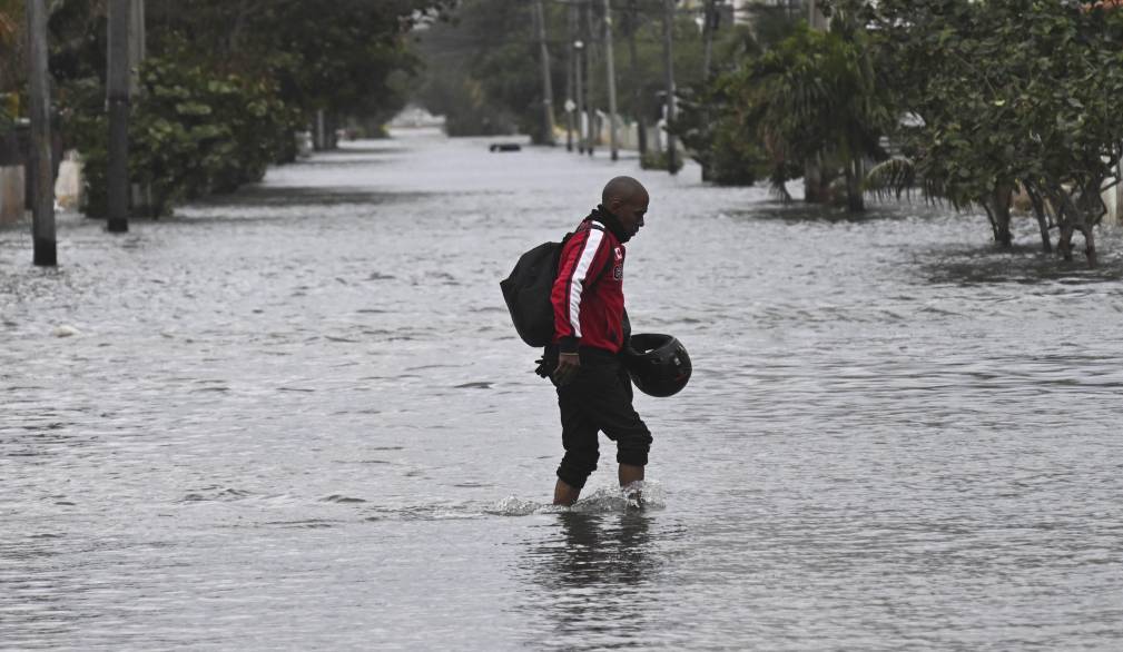 A man wades through a flooded street in Havana after the arrival of a cold front on February 1, 2026