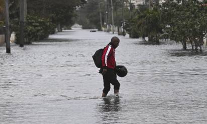 A man wades through a flooded street in Havana after the arrival of a cold front on February 1, 2026