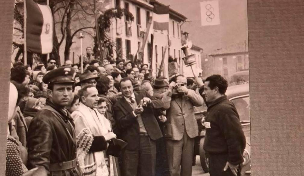 Immagine storica del passaggio della fiaccola dalle mani dei tedofori trevigiani a quelle dei tedofori bellunesi, a Fener