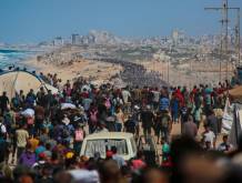 Palestinesi camminano verso Gaza City lungo la strada Al-Rashid - Foto AFP/SIR