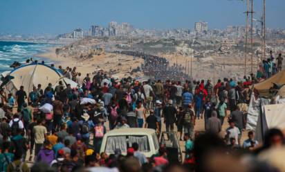 Palestinesi camminano verso Gaza City lungo la strada Al-Rashid - Foto AFP/SIR