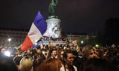 Elettori festeggiano a Parigi dopo il secondo turno di domenica