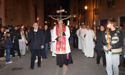 Sulle strade della città, dietro alla croce, accompagnati da san Francesco