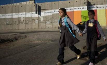 Una bambina e un bambino davanti al muro costruito dal Governo israeliano in Cisgiordania. Per gentile concessione di WeWorld ed Azione contro la fame